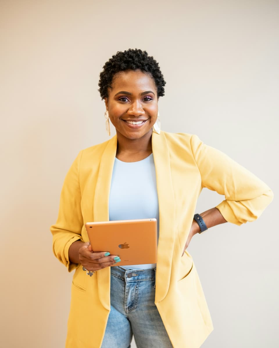 Maya Brooks, founder of Clarity Bookkeeping, smiling and holding a tablet